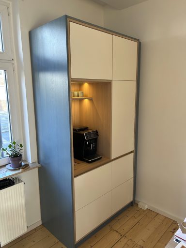 Kaffeeküche Moderner Küchenschrank mit Kaffeemaschine und geschlossenen Fächern.