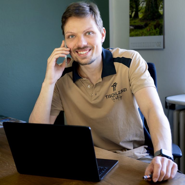 Person führt ein telefonisches Erstgespräch zur Projektplanung.
